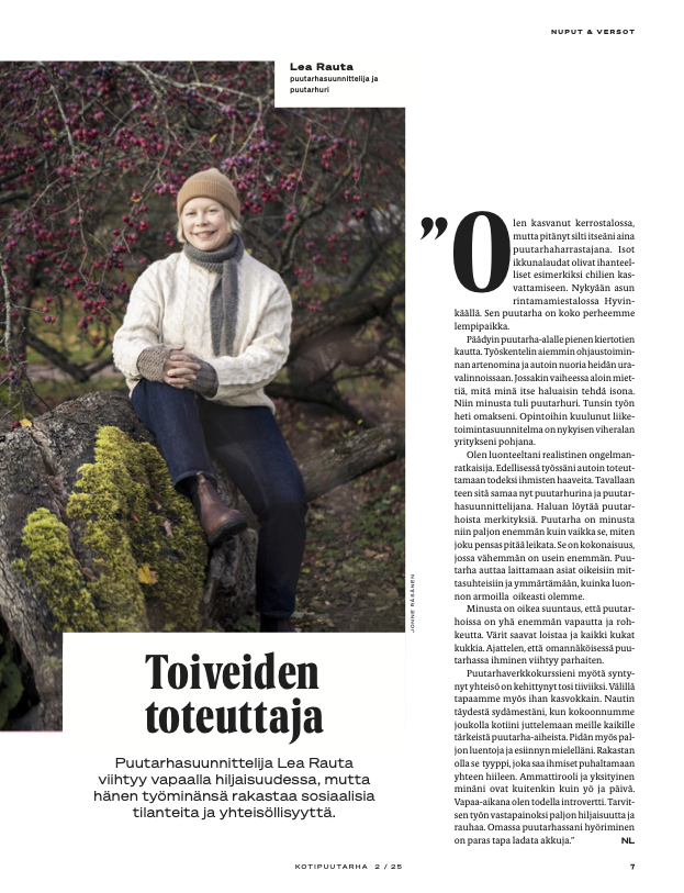 Kotipuutarha-lehden juttu. Hymyilevä nainen istuu kivillä kukkivien puiden ja sammalen keskellä, lehtiartikkelin sivun kuvassa.